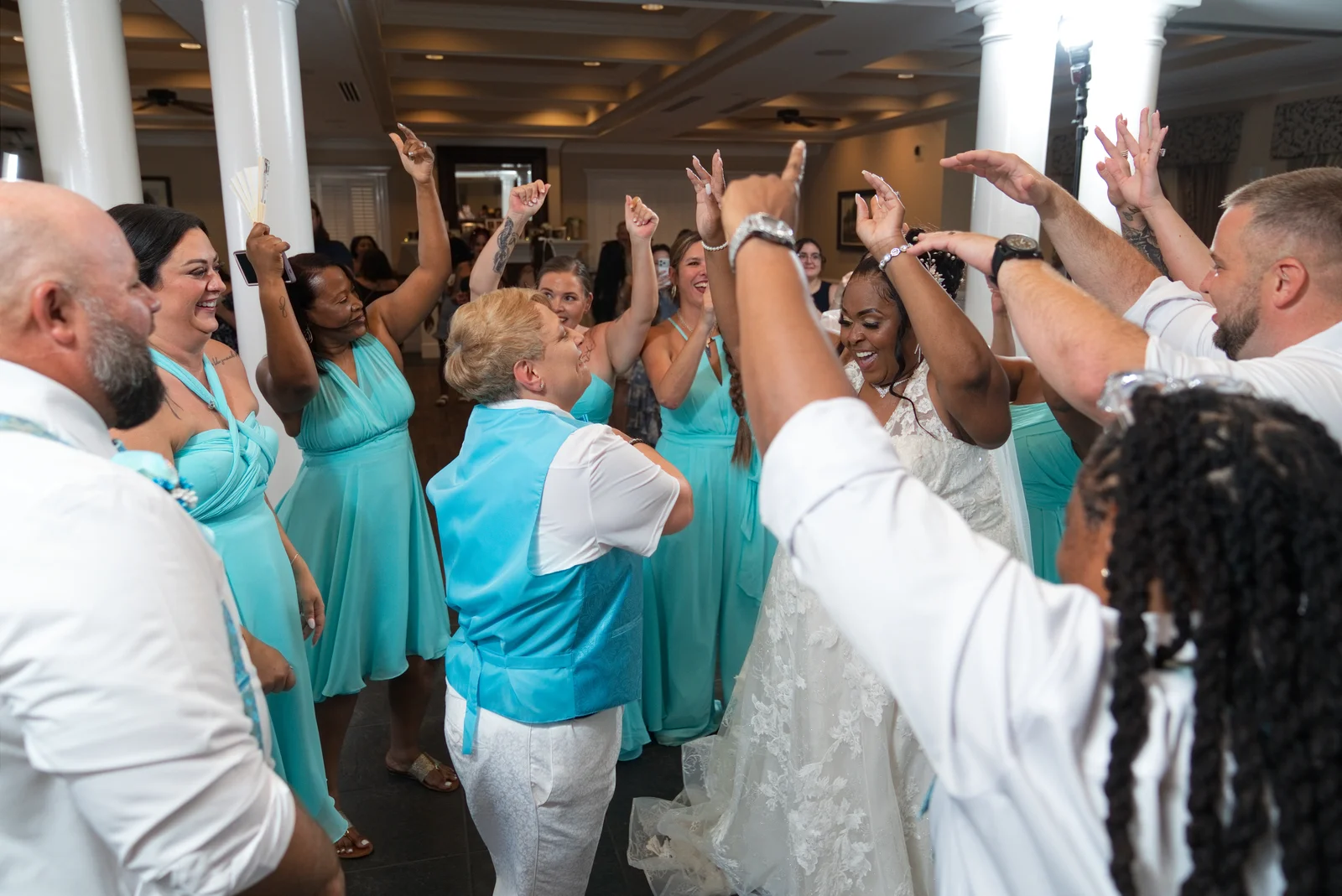 A joyful wedding dance floor surrounded by family and friends